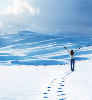 Happy woman jumping at winter mountains, active female enjoying nature, girl playing in the snow, teen having fun outdoor, healthy lifestyle and wintertime holidays vacation concept